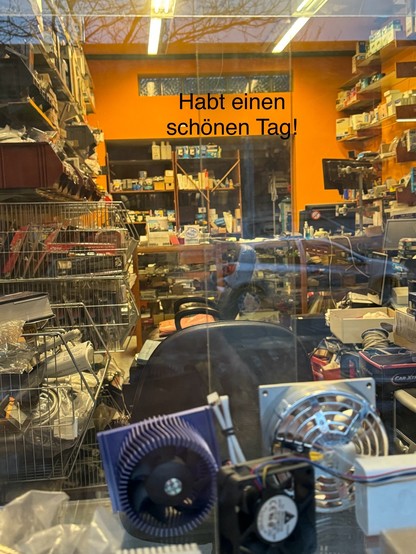 Blick durch das Fenster in einen völlig vermülllten Laden mit Computer Ersatzteilen