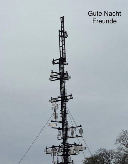 A tall metal structure with various antennas and reflectors. Text in the image reads 