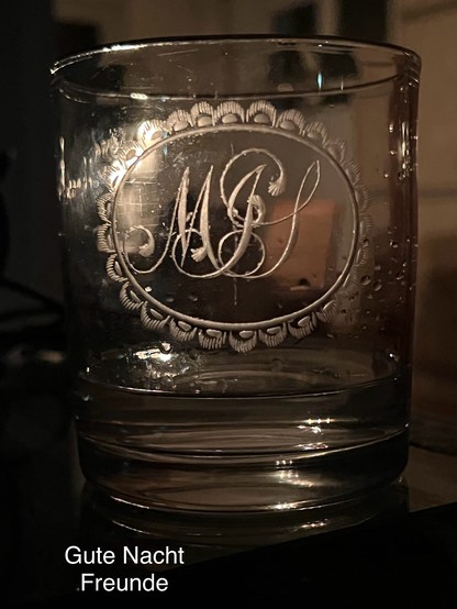 Ein Gin Glas mit etwas Gin. Es zeigt graviert Initialen, die erste ist der Buchstabe M.