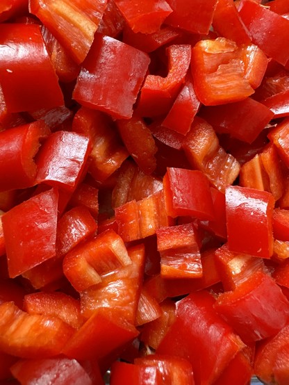 Close-up of chopped red bell peppers.

Nahaufnahme von gehackten roten Paprika.