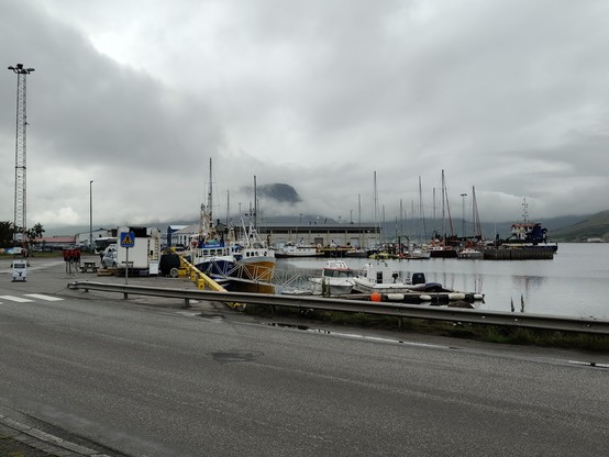 Blick auf den Fischereihafen von Ísafjörður. Direkt hinter der Hauptstraße beginnt das Hafenbecken mit einer kleinen Anzahl von Booten, vorwiegend zur Fischerei.