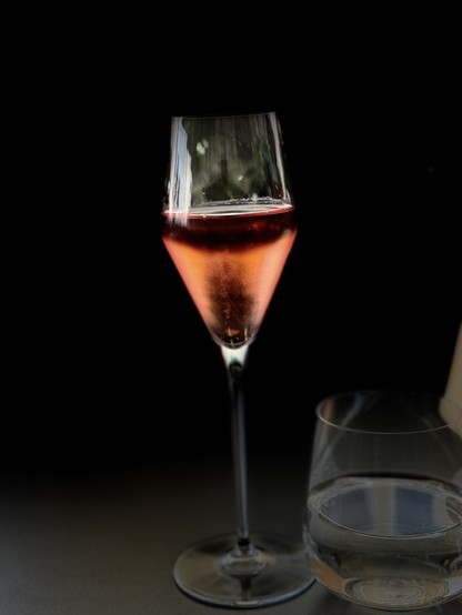 A glass of rosé wine and a glass of water on a dark background.

Ein Glas Rosé Prosecco und ein Glas Wasser auf dunklem Hintergrund.