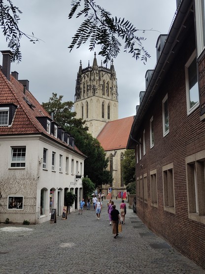 Turm und Teil der Überwasserkirche durch eine Gasse fotografiert.