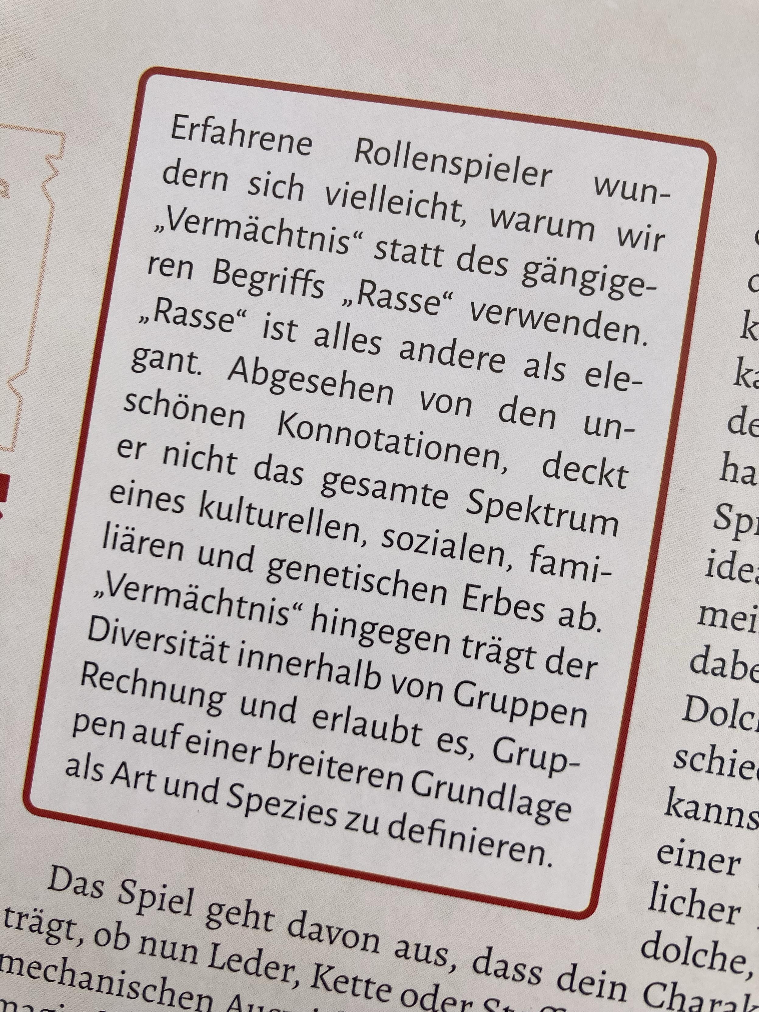 The image features text in German discussing the terms "Vermächtnis" (legacy) and "Rasse" (race) in the context of role-playing games. It addresses the implications and connotations of these terms, emphasizing diversity within groups